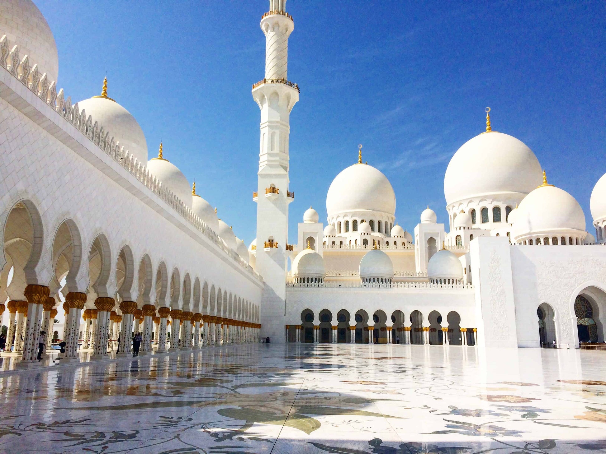 Exterior of a white domed mosque.
